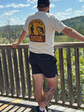 Person wearing a 'Muskoka Master Baiters' t-shirt standing on a wooden deck with a scenic background.
